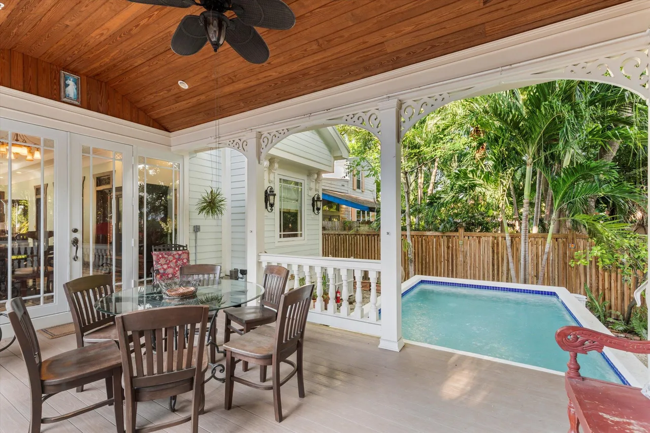 Covered porch with dining table overlooking the private pool and tropical garden